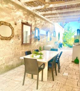 a table and chairs in a room with a stone wall at Secret Garden Chalet No. 1 in San Pietro in Bevagna