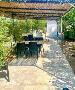 a patio with a table and chairs under a pergola at Secret Garden Chalet No. 1 in San Pietro in Bevagna +19 photos