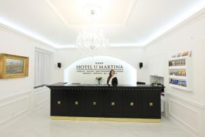 Eine Frau, die hinter einem Podium in einem weißen Raum steht. in der Unterkunft Martin Hotel Prague in Prag