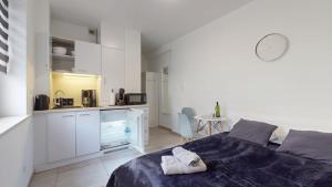 a bedroom with a bed and a small kitchen at Studio Fibra Choco in Rybnik