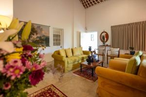 a living room with yellow couches and a table at Heuvel Villa Kandy in Kandy