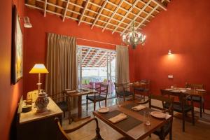 a dining room with red walls and tables and chairs at Heuvel Villa Kandy in Kandy +37 photos