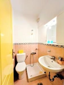 a bathroom with a toilet and a sink at Lime Andros Maisonette by HOSTANDROS in Apróvaton