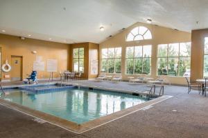 a large indoor pool with chairs and tables and windows at TownePlace Suites by Marriott Lafayette in Lafayette