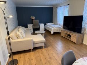 a living room with a couch and a flat screen tv at Kirkenes Hotell in Kirkenes