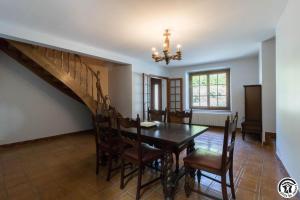 a dining room with a table and chairs and a staircase at Calme et montagne in Cazaux-Layrisse