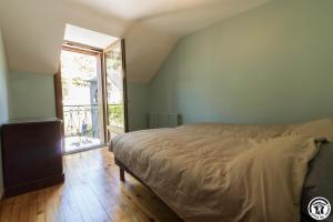 a bedroom with a bed and a large window at Calme et montagne in Cazaux-Layrisse