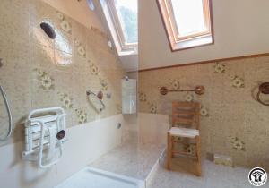 a bathroom with a shower and a chair in it at Calme et montagne in Cazaux-Layrisse +19 photos