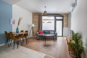 a living room with a couch and a table at Charmant cocon avec jacuzzi - Bordeaux Centre in Bordeaux