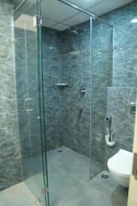a bathroom with a glass shower with a toilet at Firefox Hotel and Resort in Moinabad