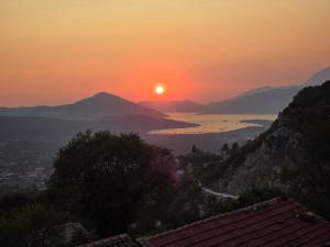 a sunset with the sun setting over the water and mountains at Dream View Villa in Kotor