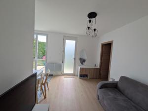 a living room with a couch and a table at Maison Le cottage in Crosne +1 photo