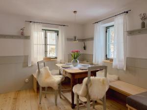a dining room with a table and chairs and windows at Altes Zollhaus in Neukirchen