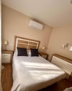 a bedroom with a large white bed with two pillows at Apartamento La Hera in Belvis de Monroy