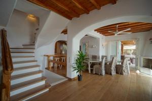 a living room with a staircase and a dining room at Zinas Villas in Fanari
