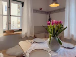 a table with two plates and a vase of flowers on it at Altes Zollhaus in Neukirchen