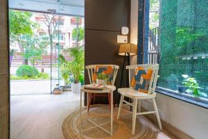 two chairs and a table in a room with a window at SRS Vivanta in Bangalore