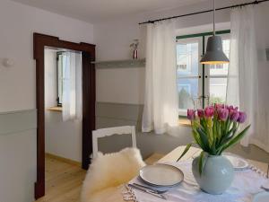 a dining room table with a vase of flowers on it at Altes Zollhaus in Neukirchen