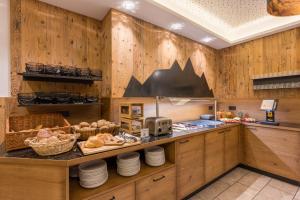 a kitchen with wooden walls and a counter with food at Hotel Alpenkönigin - ALPINE LUXURY in See