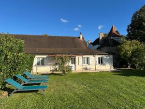 two lounge chairs sitting in the yard of a house at L'Orée du Bois in La Charmée