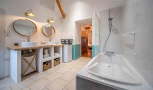 a bathroom with two sinks and a tub and mirrors at L'Orée du Bois in La Charmée +27 photos