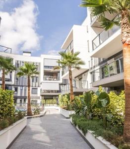 an apartment building with palm trees and a walkway at Apartamento Esencia in Jávea