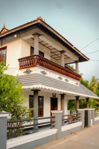 a house with a balcony on top of it at Backwater Home in Kumarakom