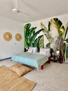 a bedroom with a bed with a mural of leaves at Olacoco by Olamanga in Jambiani +89 photos