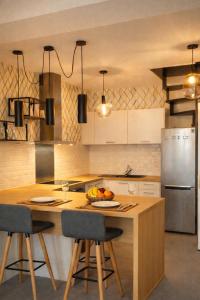 a kitchen with a wooden island with two bar stools at Appartements à Oloron in Oloron-Sainte-Marie