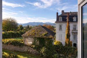 a large white house with a building in front of it at Appartements à Oloron in Oloron-Sainte-Marie