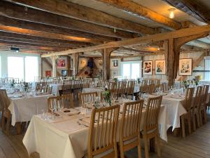 a banquet hall with white tables and chairs at Skjerjehamn in Ånneland