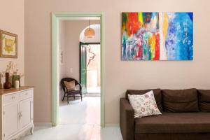 a living room with a couch and a painting on the wall at Aerino in Symi