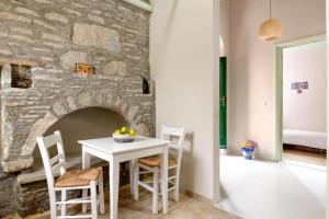 a dining room with a table and a stone wall at Aerino in Symi