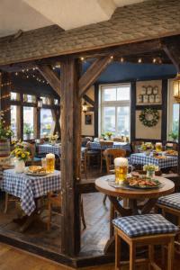 a restaurant with tables and chairs in a room at Burghof Hotel in Schwarzatal