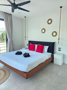 a bedroom with a large bed with red pillows at Villa Mona in Nathon Bay +27 photos