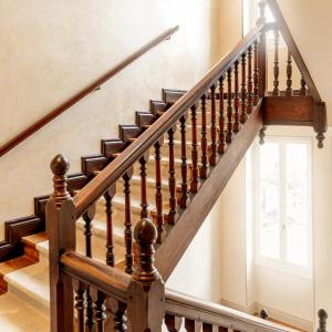 a staircase with wooden railings and a window at Hotel Saint Julien in Biarritz