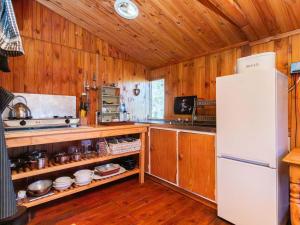 a kitchen with a white refrigerator and wooden walls at Bloukrans Off-Grid Cabin in Montagu