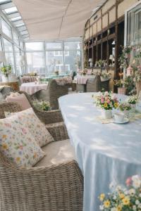 a long table with wicker chairs and tables with flowers at Burghof Hotel in Schwarzatal +9 photos