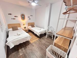 a small room with two beds and a ladder at Dúplex Empul Brisa Marina in Los Caños de Meca