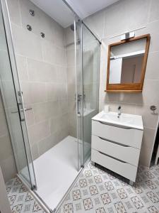 a bathroom with a shower and a sink and a mirror at Dúplex Empul Brisa Marina in Los Caños de Meca