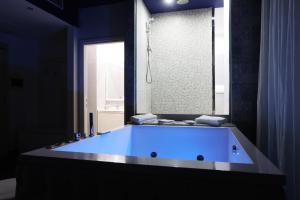 a large blue tub in a bathroom with a window at Hotel La Fayette Giugliano Licola in Giugliano in Campania