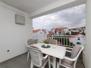 a white apartment with a balcony with a white table and chairs at Villa Supe in Supetar