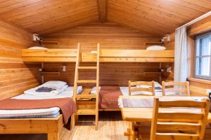 a room with bunk beds in a log cabin at Fell Centre Kiilopää, Cabins in Lukkarinsaari