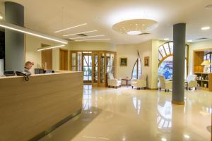 a man sitting at a counter in a hospital lobby at Corvin Hotel Budapest Sissi Wing in Budapest