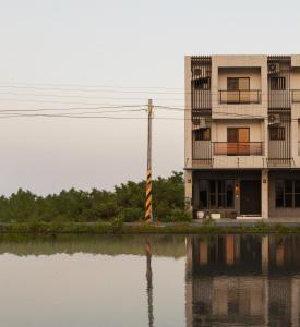 an apartment building next to a body of water at 參穗 SunSui Guesthouse in Sanxing