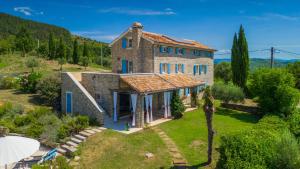 an external view of a stone house with blue windows at Villa Pigini by Villas Guide in Livade
