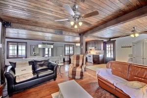 a living room with leather furniture and a dining room at Spa & Kenogami Lake - Chalet le Rustik in Saguenay