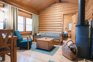 a log cabin bedroom with a bed and a fireplace at Fell Centre Kiilopää, Hotelli Niilanpää in Saariselka