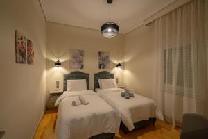 a bedroom with two beds with white sheets and pillows at Meteora Rockside Lodge in Kalabaka