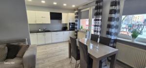 a kitchen and living room with a table and a couch at Apartament SORENTO 7 in Gorzów Wielkopolski